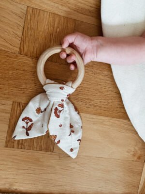 En bebishand som håller i en bitring.